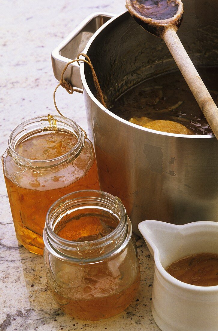 Orange marmalade in jars and pan