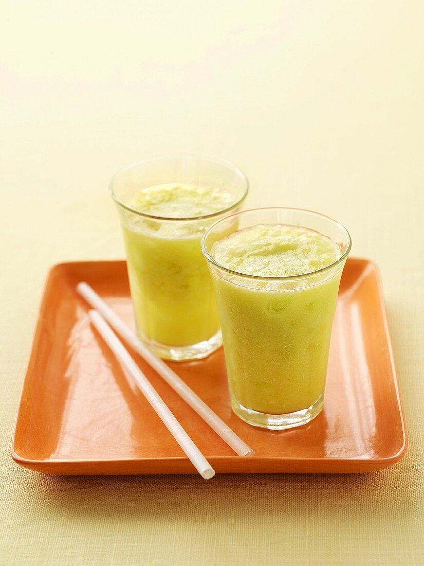 Two glasses of honeydew melon and pineapple juice