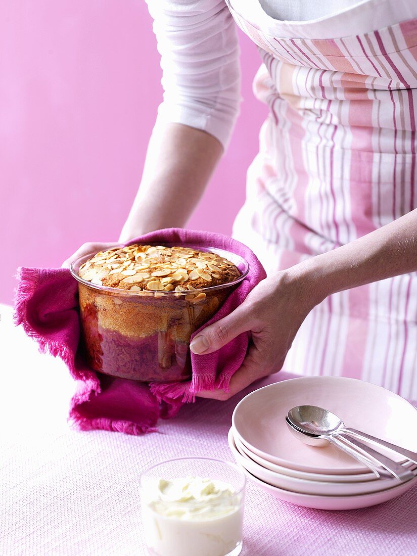 A woman serving a plum and almond bake