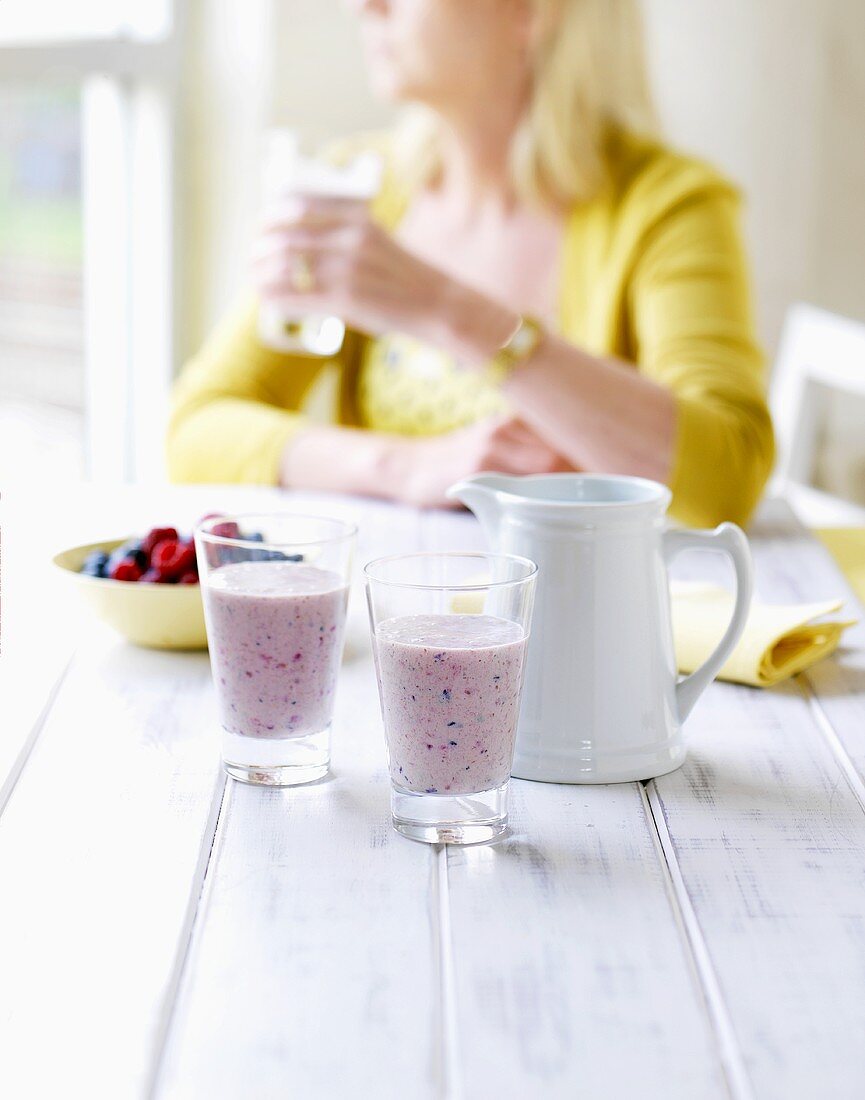 A woman with plum and berry smoothies
