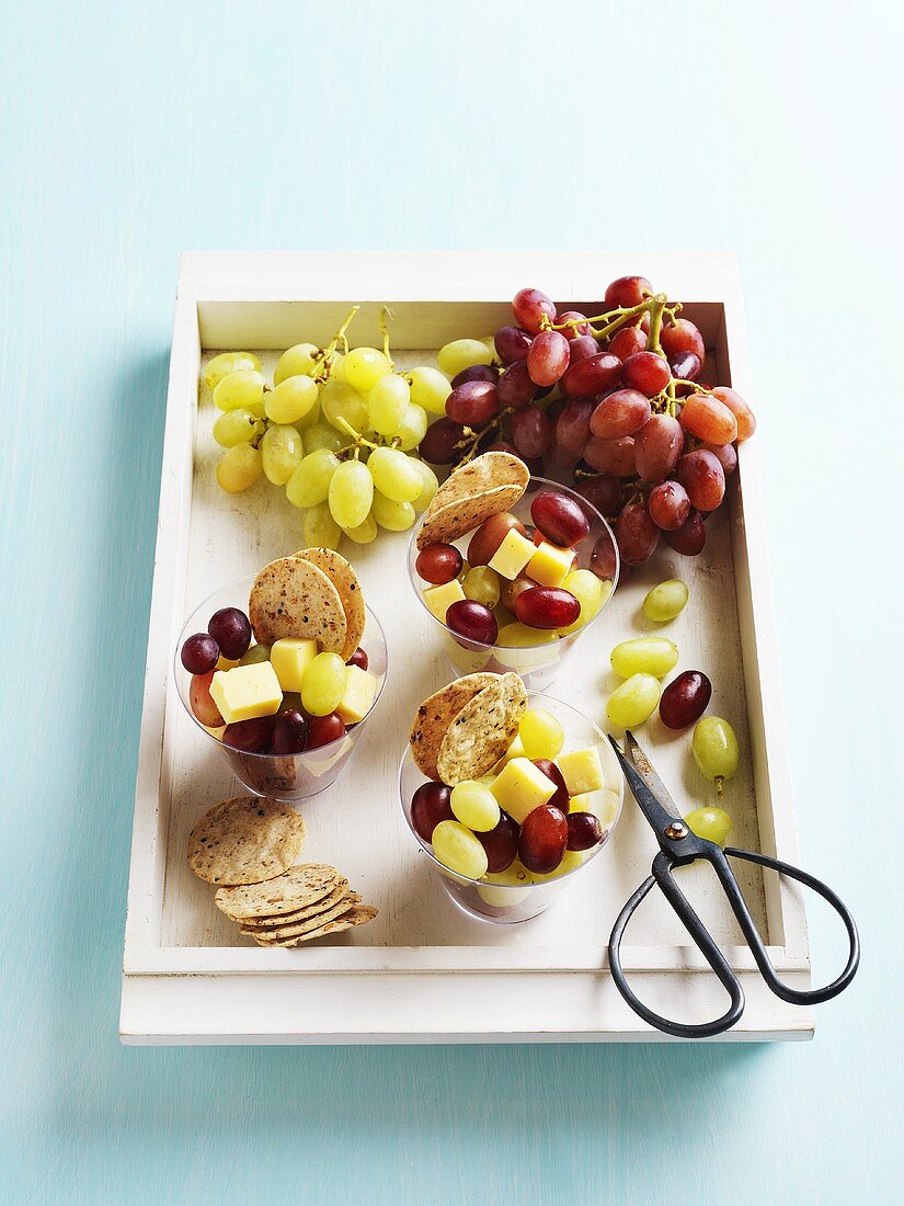 A tray of snacks - grapes, cheese cubes and crackers