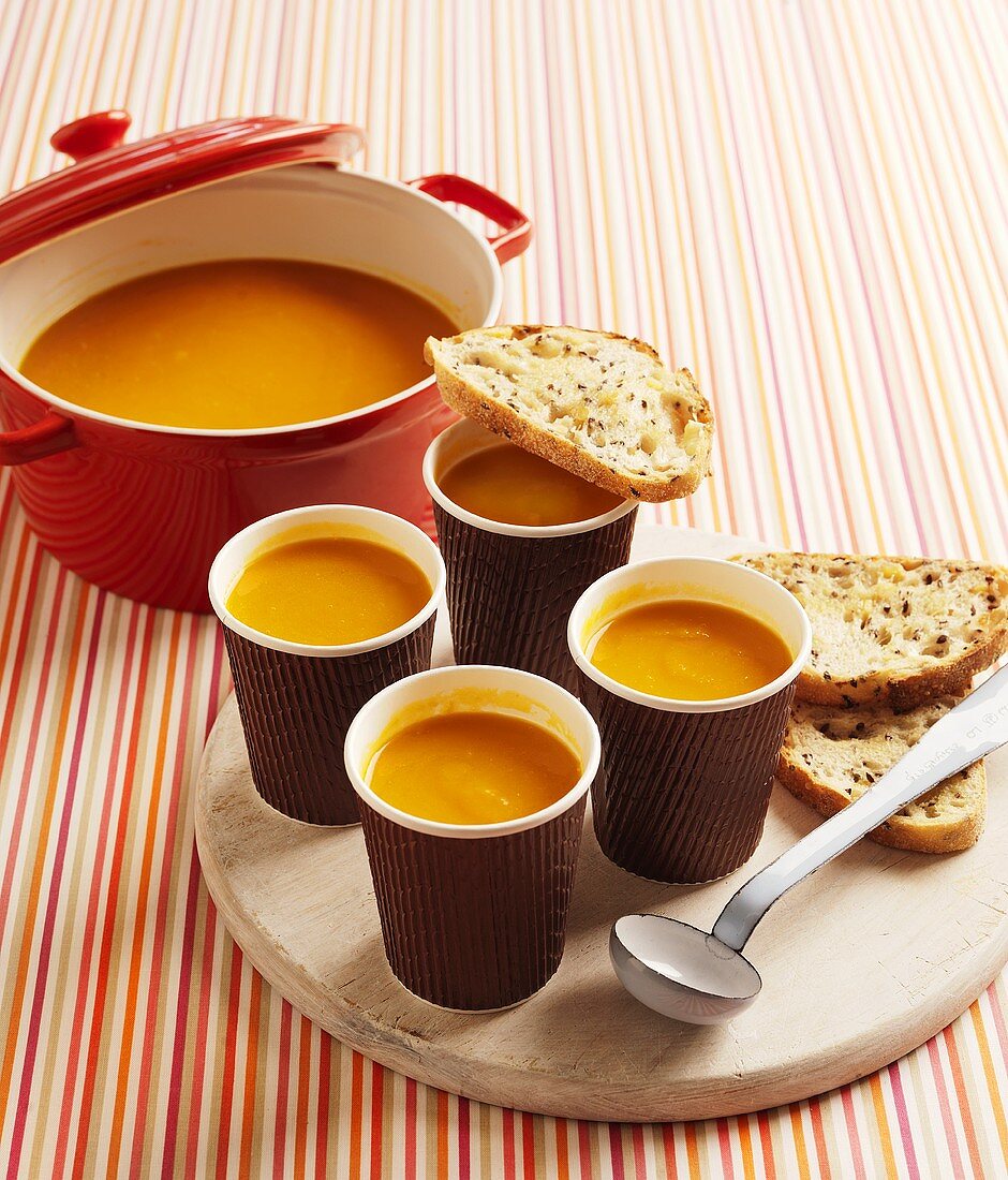 Pumpkin soup in pan and paper cups