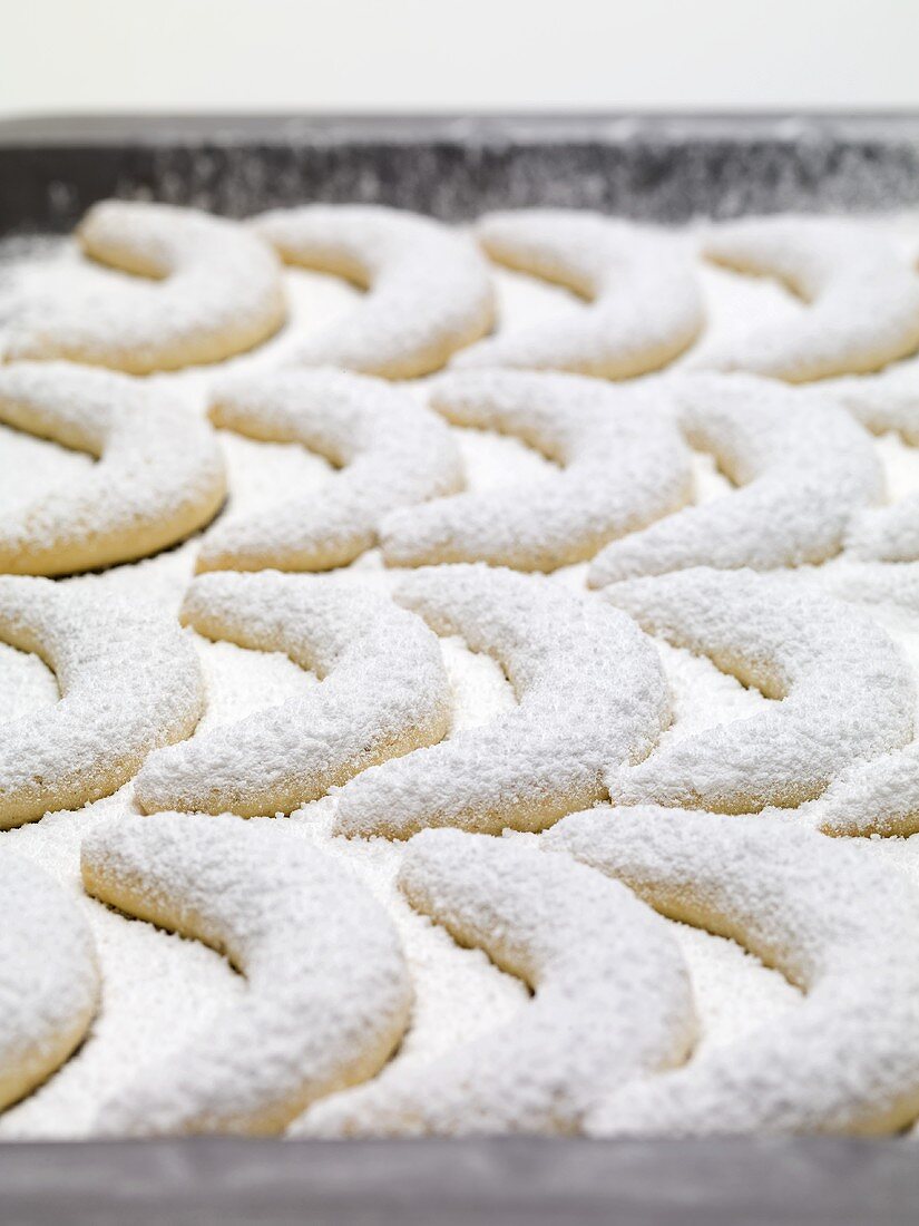 Vanilla crescents with icing sugar on baking tray