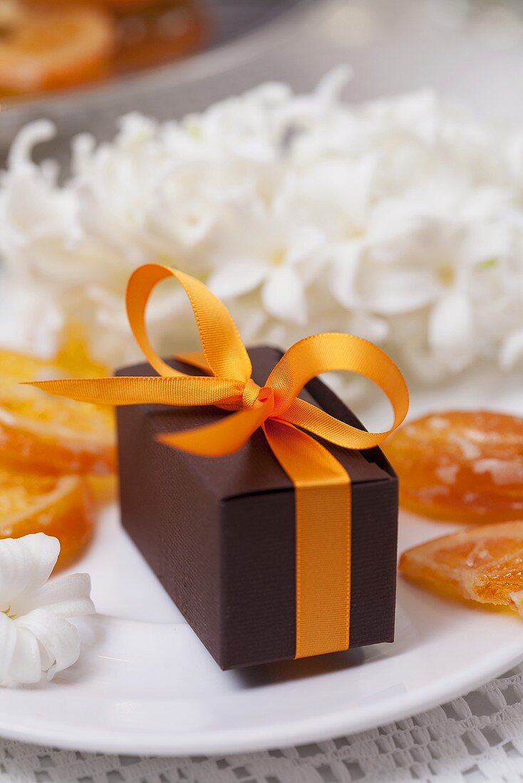 Small parcel among candied orange slices on plate