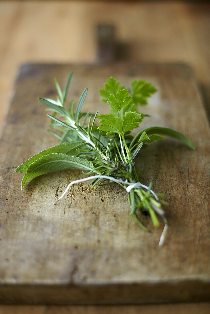 A bouquet of herbs on a wooden board