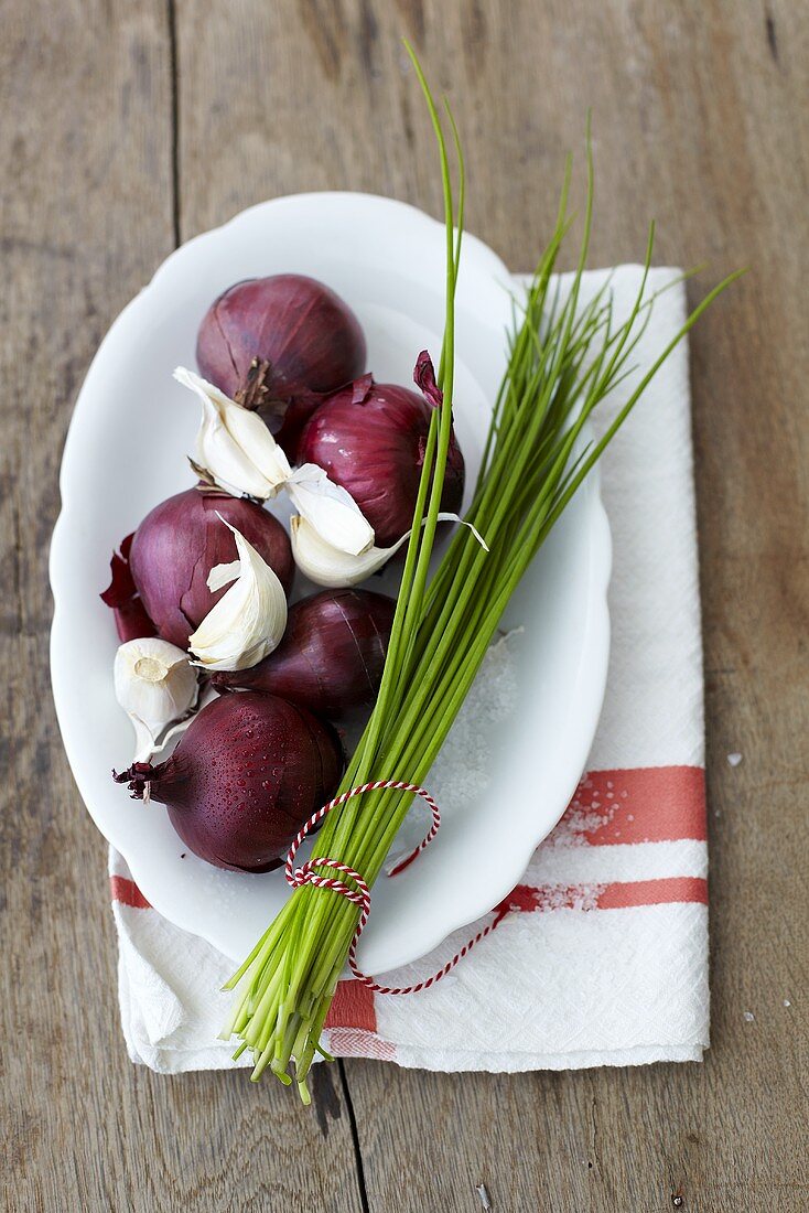 Red onions, garlic and chives on a plate