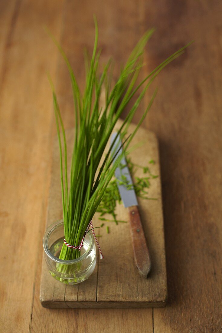 Chives in a bunch and cut on a wooden board