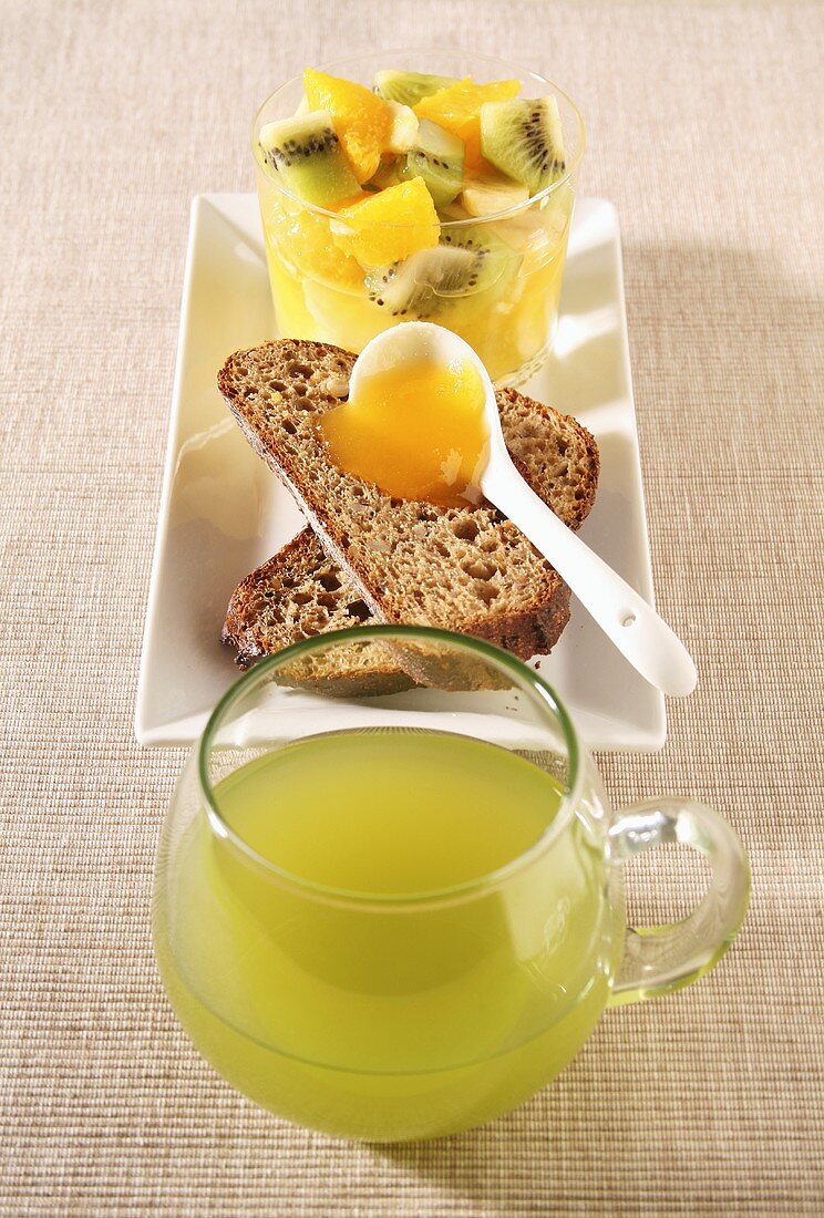 Grüner Tee, Marmeladenbrot und Obstsalat