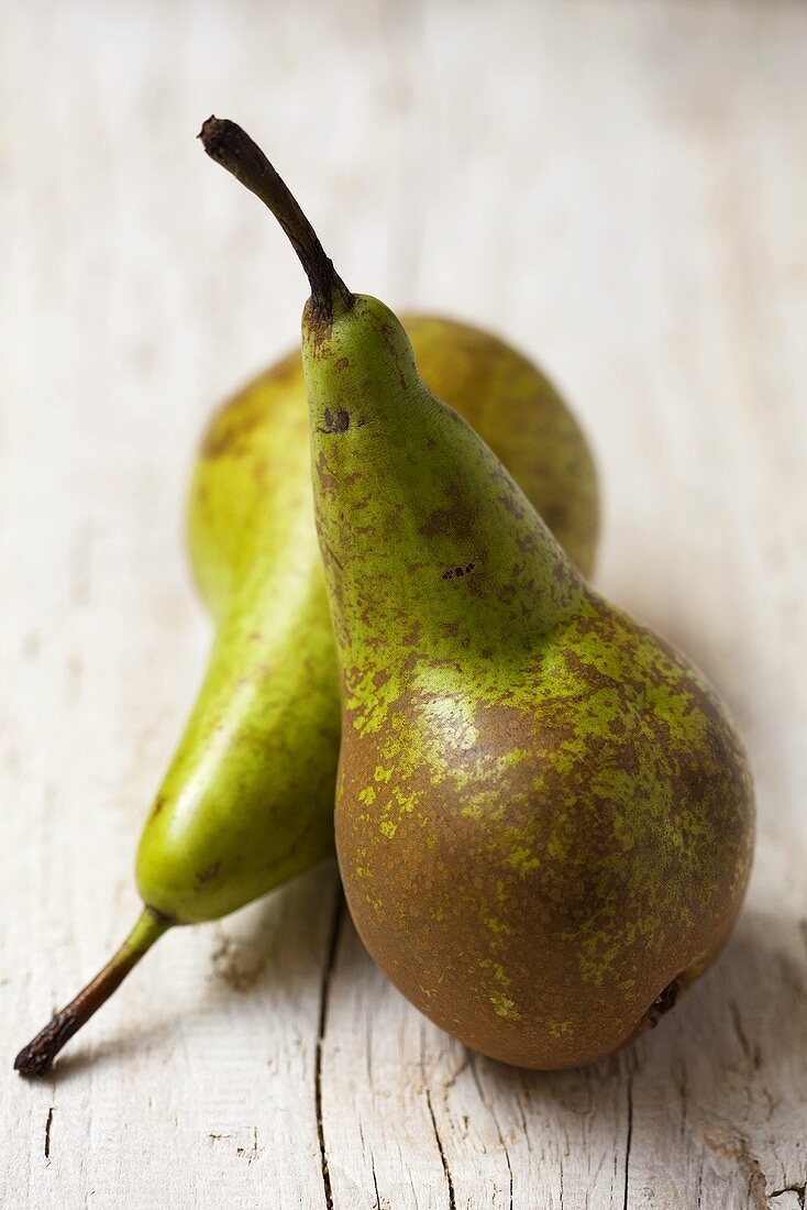 Two Comice pears on wooden background