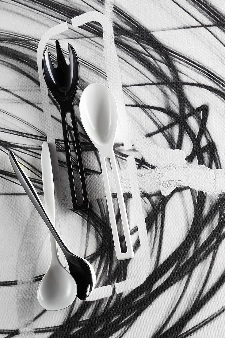 Black and white salad servers and kitchen spoons