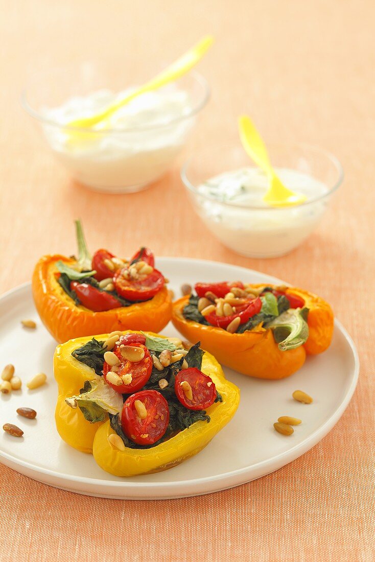 Peppers stuffed with spinach, tomatoes and pine nuts, yoghurt sauce