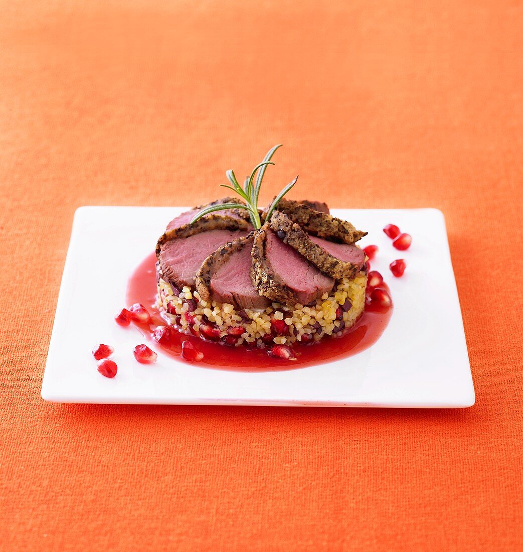 Coffee crusted loin of venison with bulgur and pomegranate seeds
