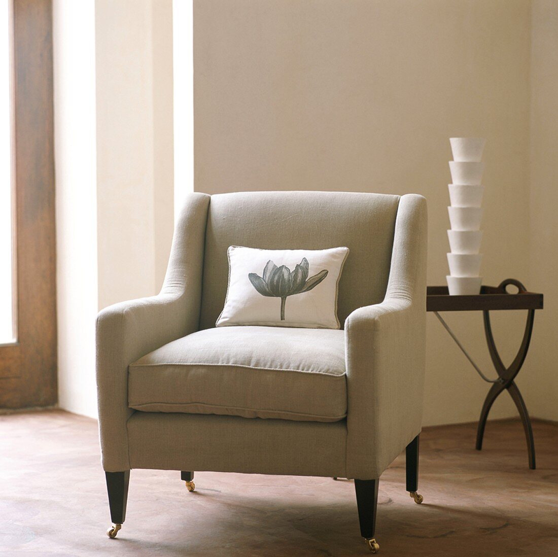 Armchair on dainty castors and stack of beakers on side table