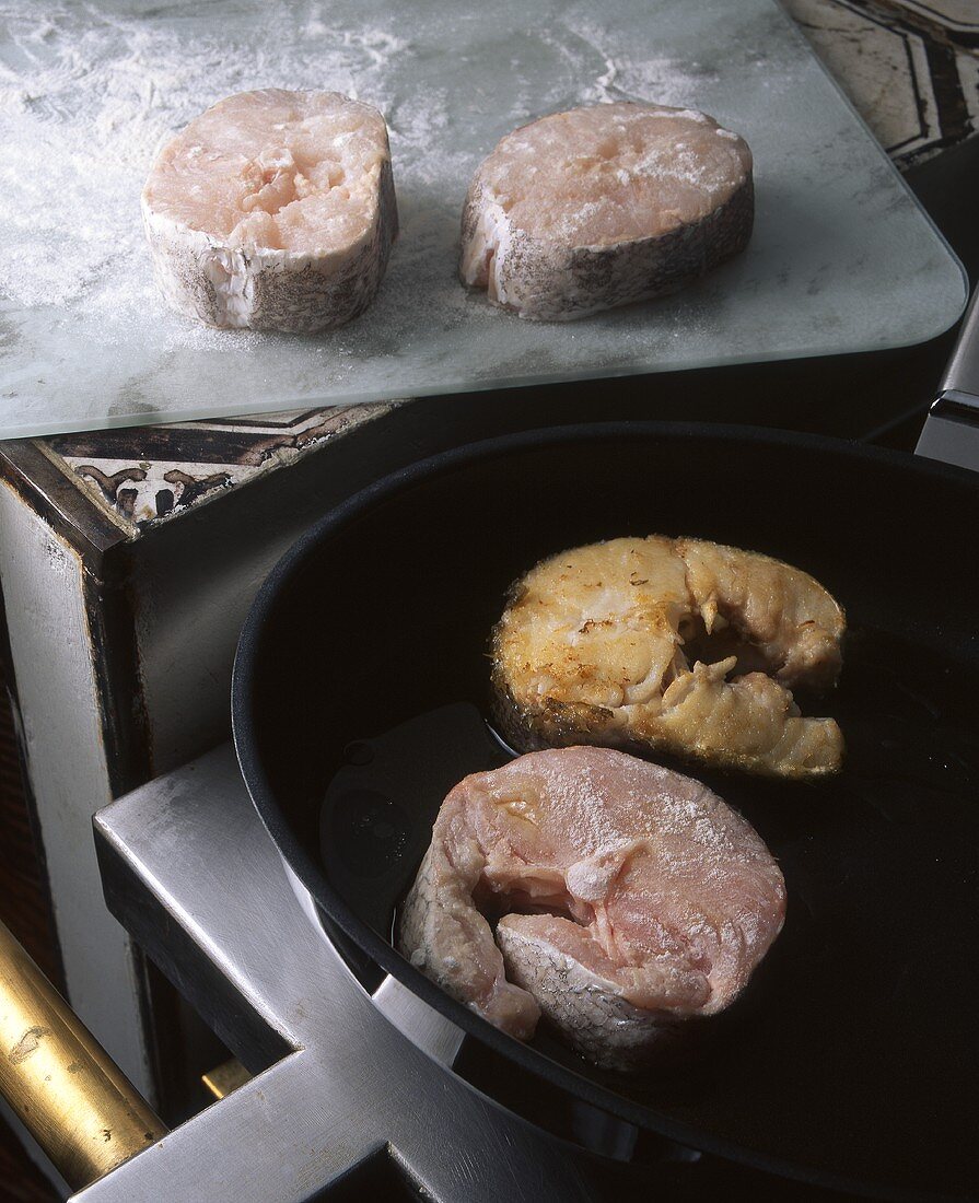 Tuna steaks being fried in a pan