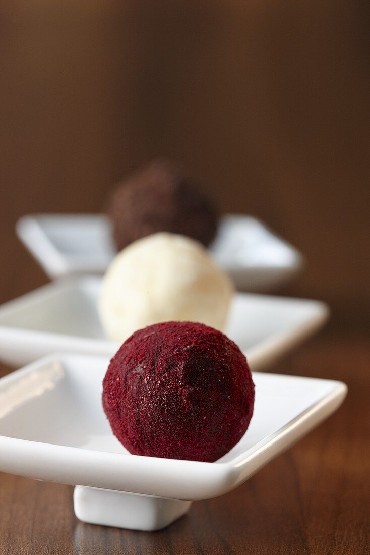 A rum truffle with a chocolate crust, a champagne truffle and a chocolate truffle with a cassis crust