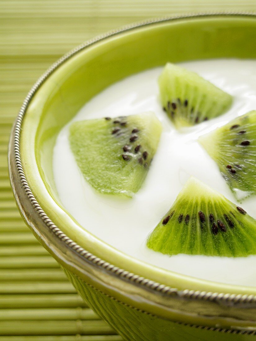 Naturjoghurt mit Kiwis in grüner Schale (Close Up)