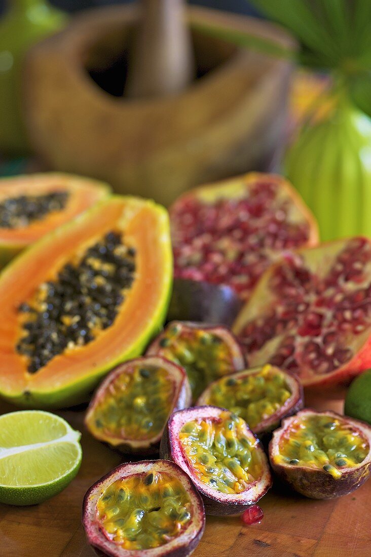 Frische exotische Früchte (Purpurgranadillas, Papaya, Granatäpfel, Limette)