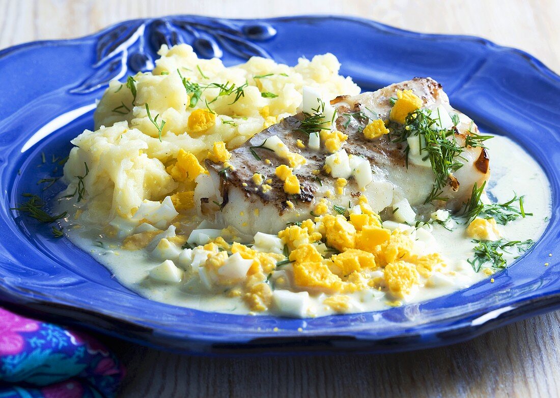 Fish fillet with an egg and mustard sauce and mashed potatoes