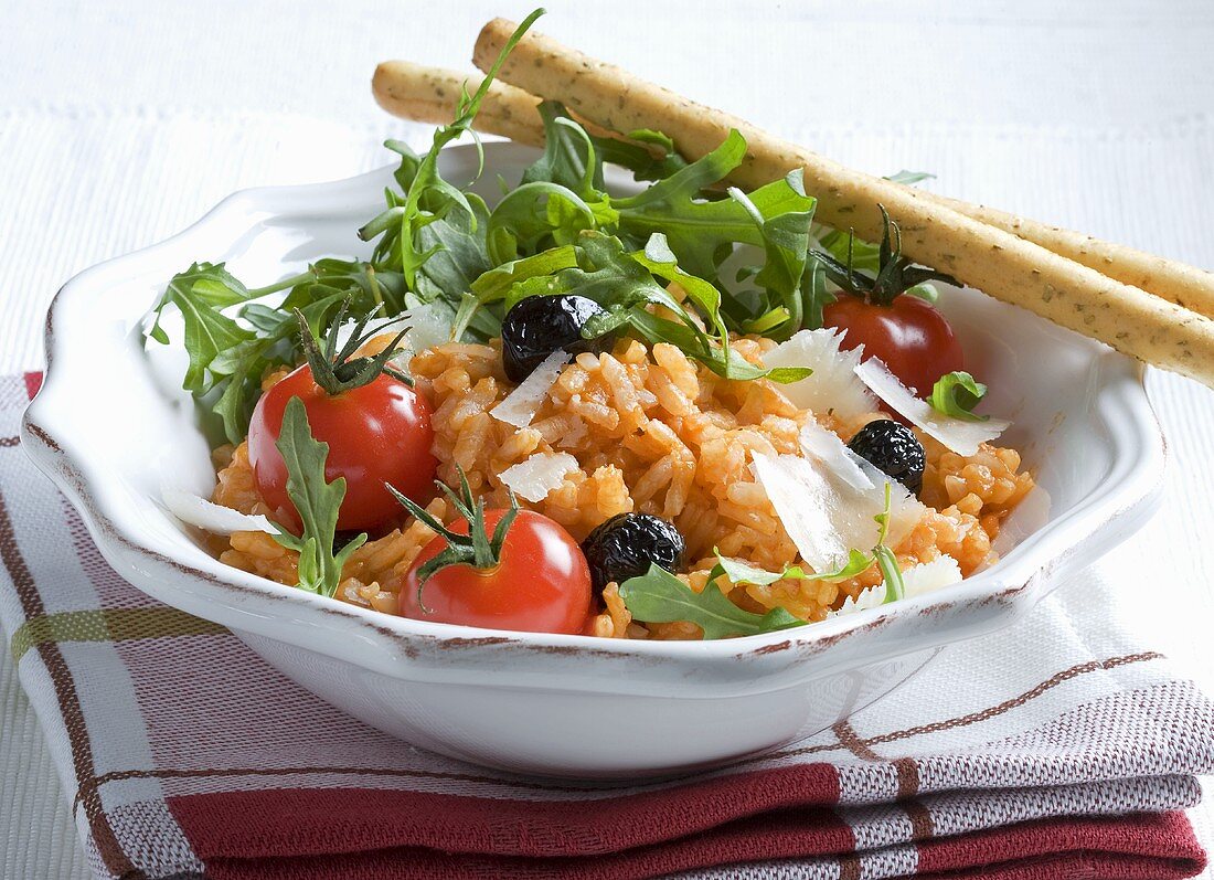 Tomato risotto with rocket, Parmesan, olives and grissini