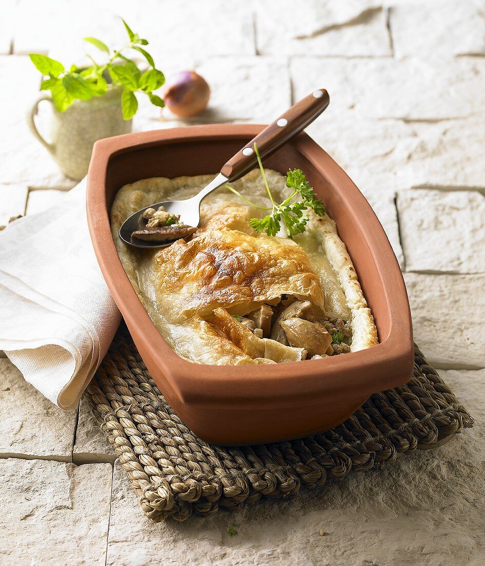 Kulebiak (yeast dough pie, Poland) in a terracotta dish