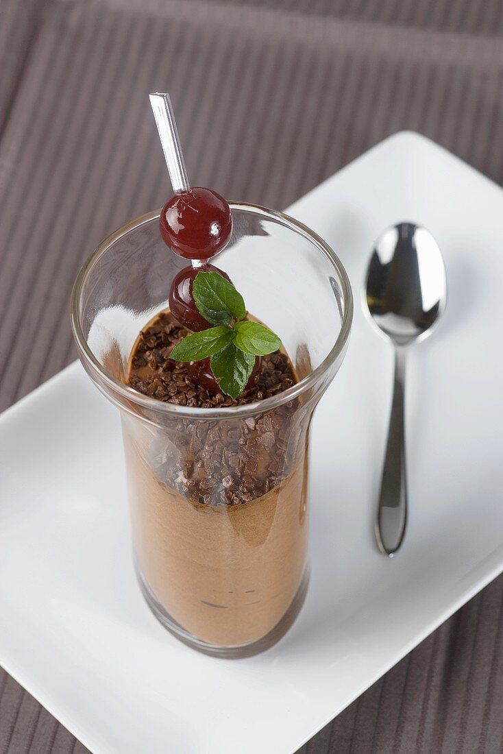 Chocolate mousse with cherries and mint leaves