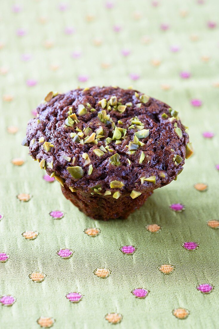 A muffin with pistachios and chocolate chips