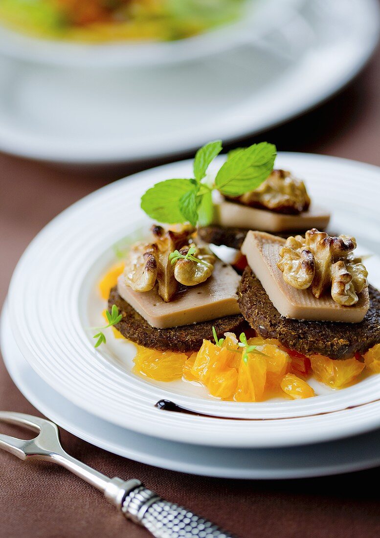Foie gras with walnuts and pumpernickel on orange salad