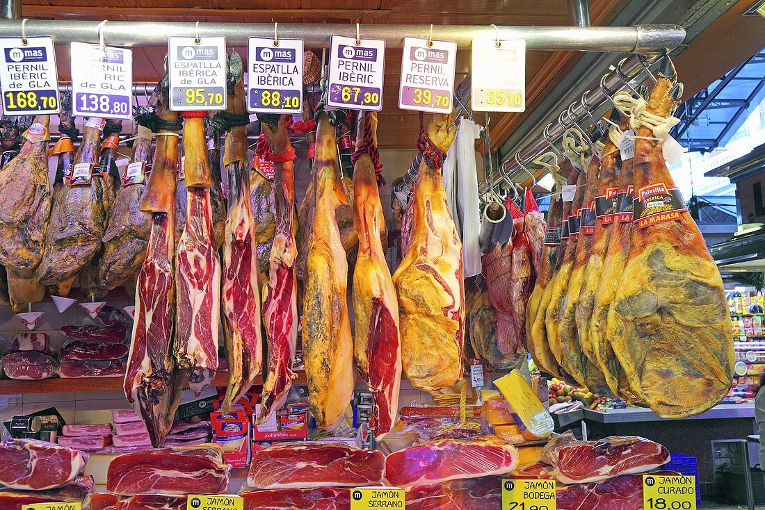 Marktstand mit verschiedenen Schinken (Mercat de St. Josep (Boqueria), Ramblas, Barcelona, Spanien)