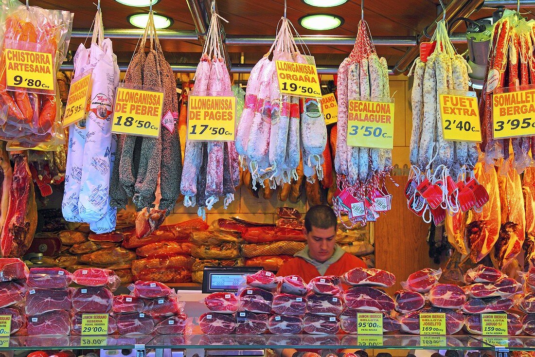 Marktstand mit Salami und Schinken (Mercat de St. Josep (Boqueria), Ramblas, Barcelona, Spanien)