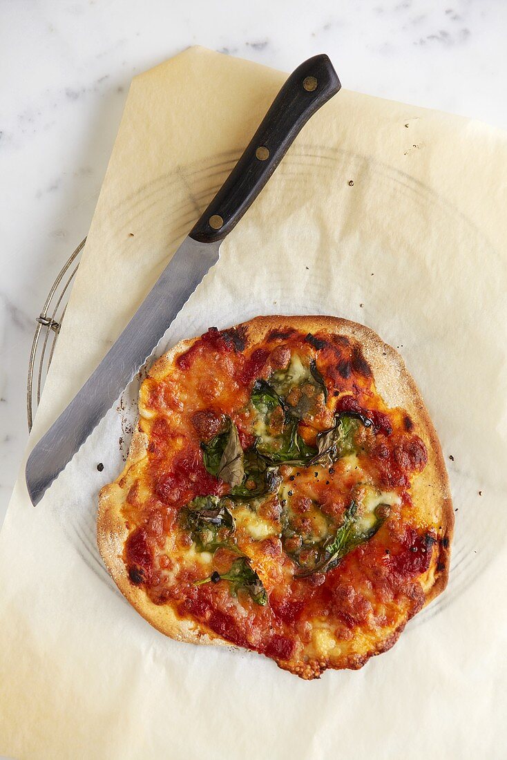 Tomato, mozzarella and spinach pizza on cake rack