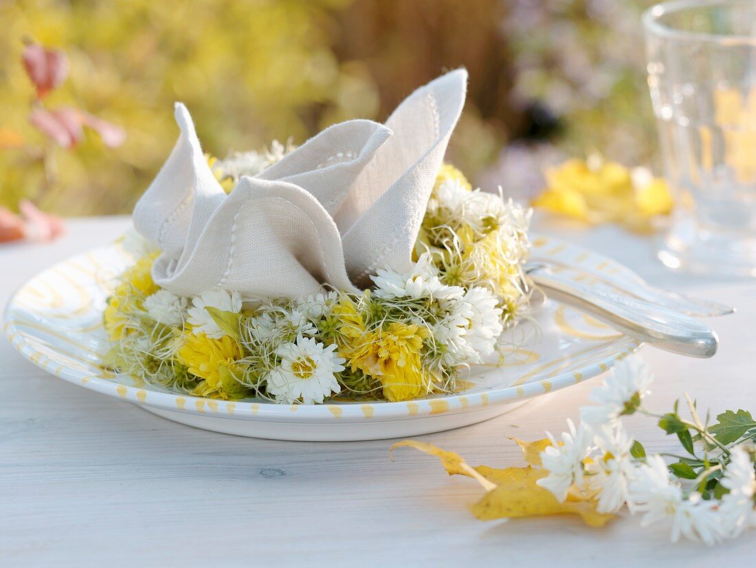 Herbstliches Gedeck mit Stoffserviette und Blumenkranz