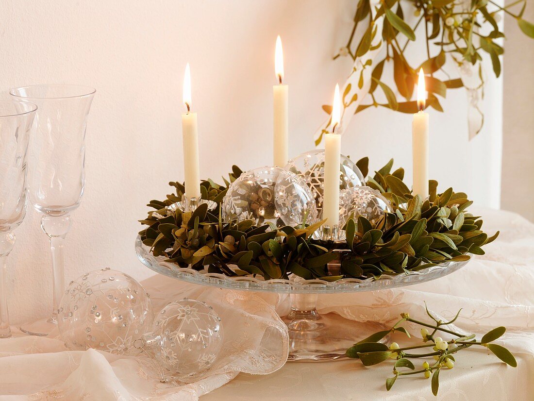 Adventskranz aus Mistel mit weissen Kerzen und Glaskugeln