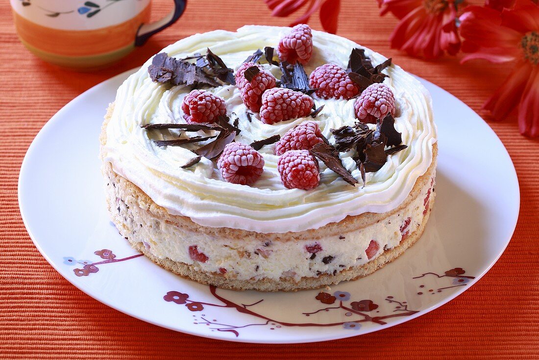 Ice cream cake with raspberries and chocolate shavings