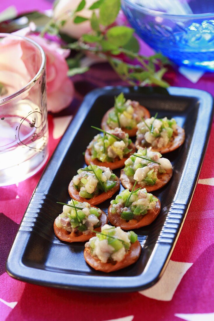 Herring tartare and peas on crackers