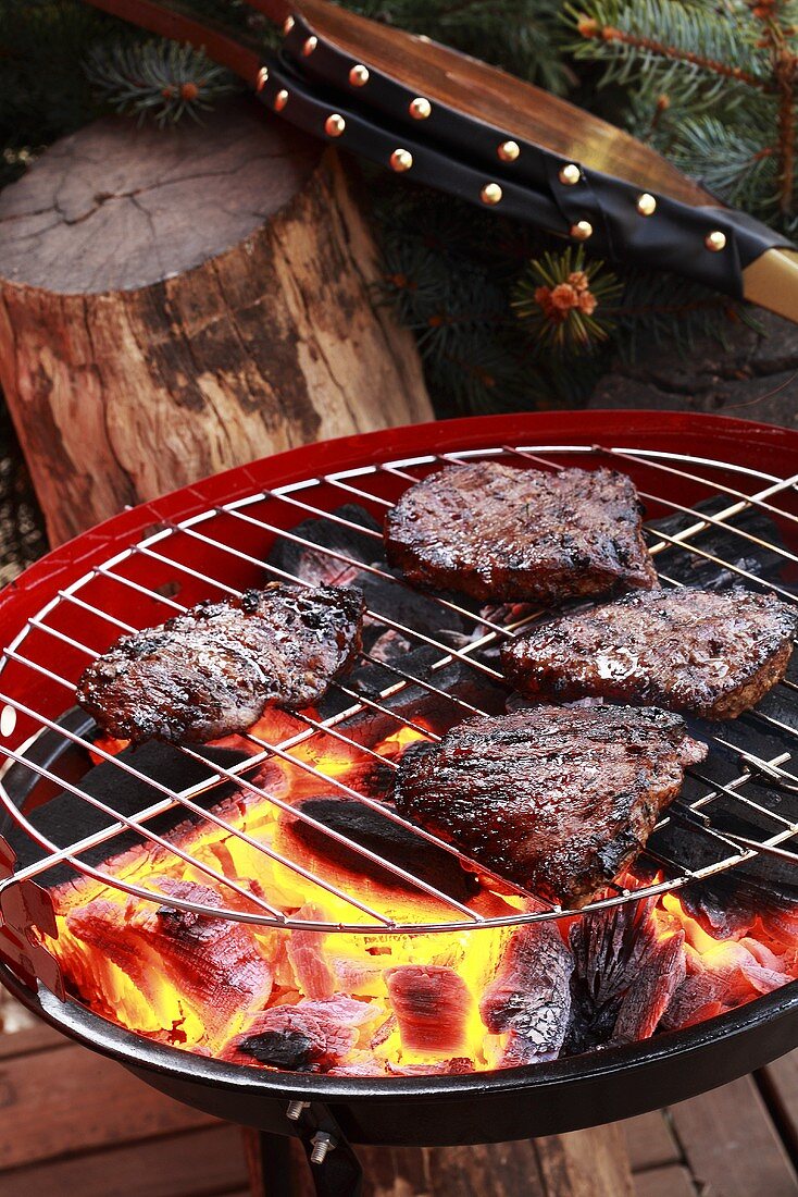 Beef steaks on barbecue