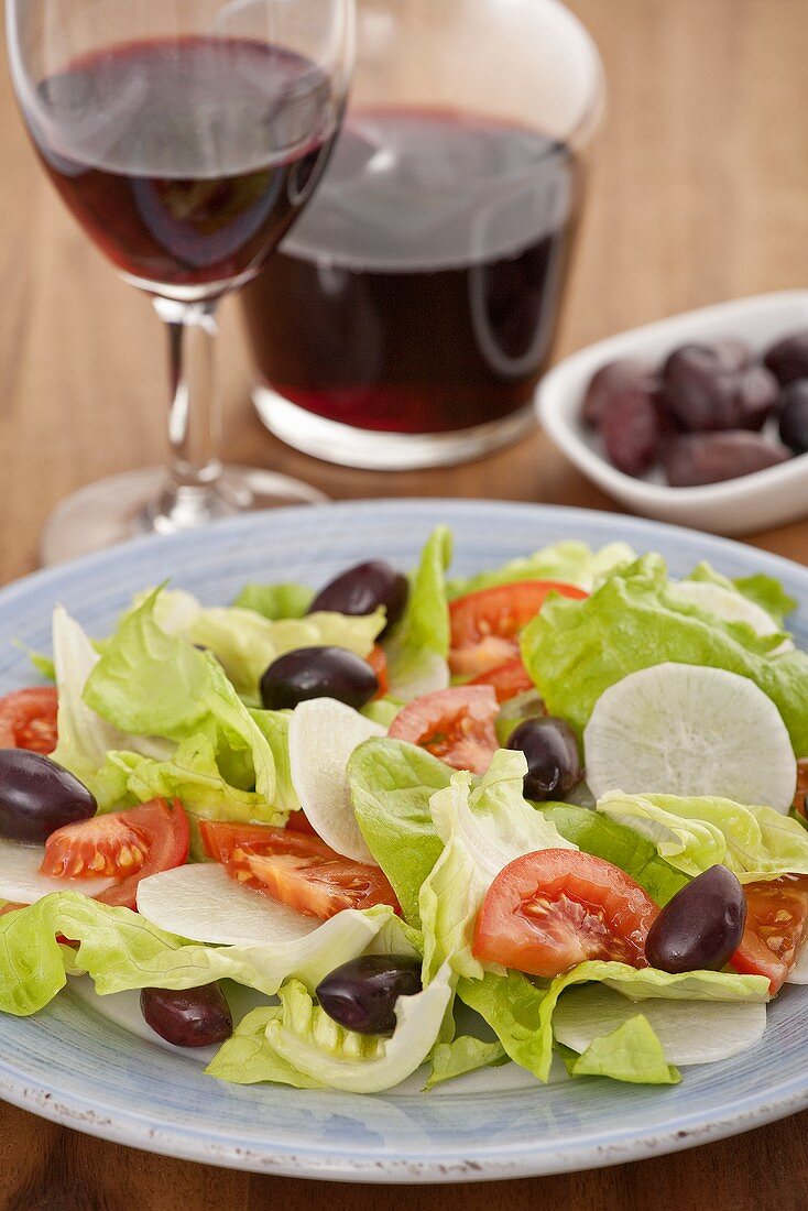 An iceburg lettuce, radish, tomato and olive salad
