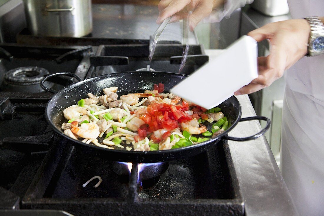 Paella zubereiten (Gemüse zugeben)
