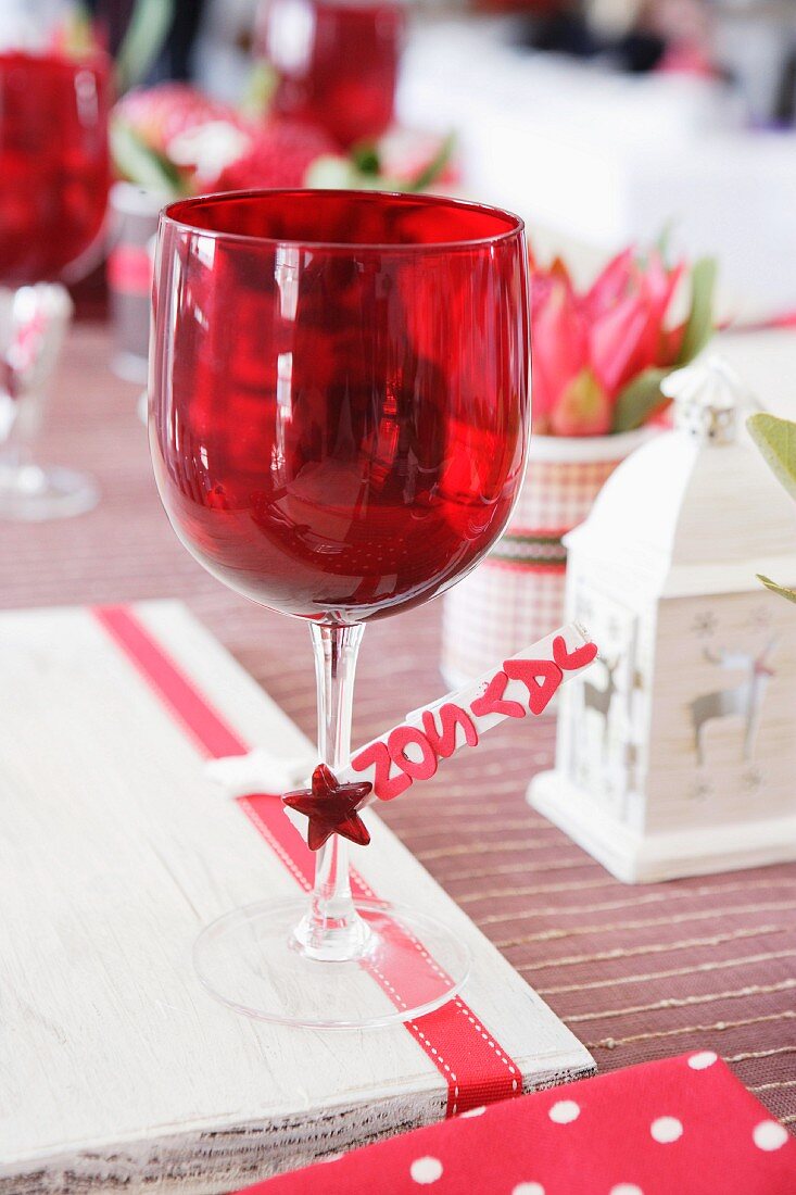 Rotes Weinglas auf einem Weihnachtstisch