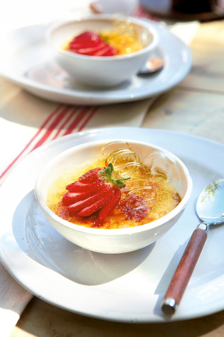 Crème brûlée with strawberry garnish