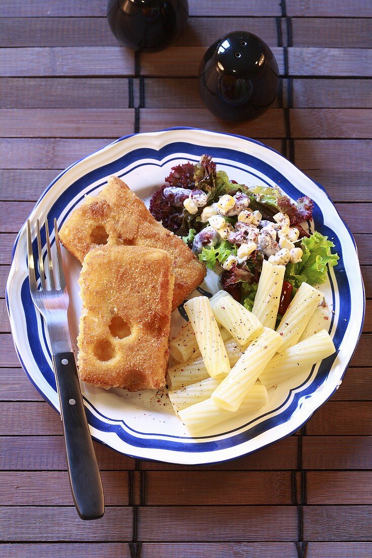 Breaded fried cheese with pasta and salad