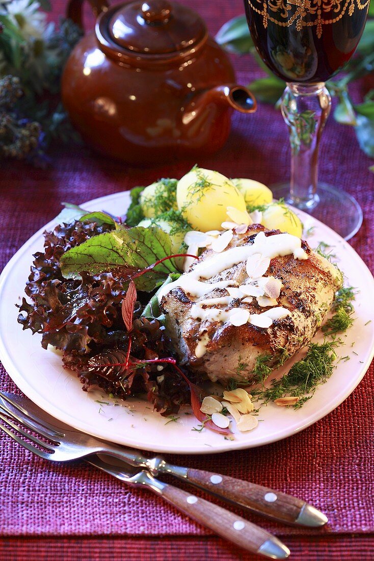 Rabbit with white wine sauce, potatoes and salad leaves