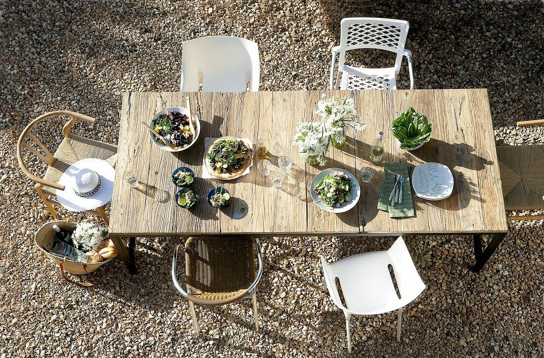 Gedeckter Tisch mit Salat im Freien