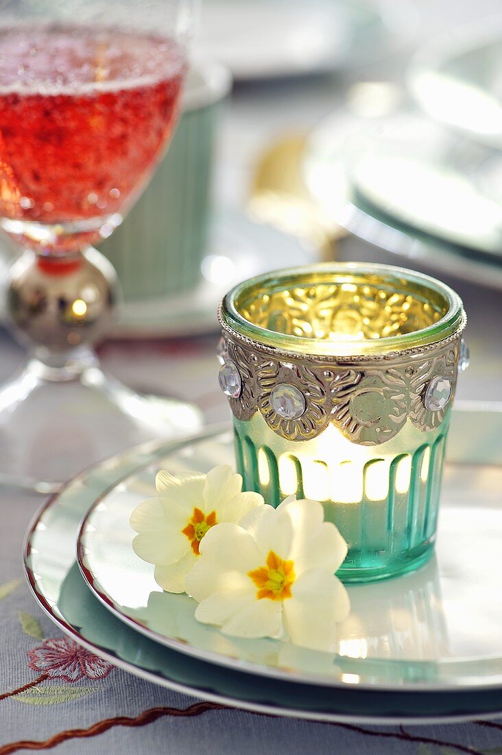 Easter place-setting with candle in glass and primroses