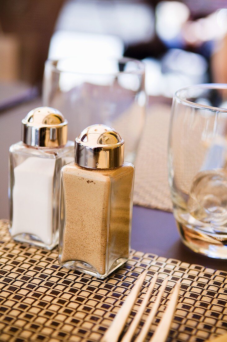 Salt and pepper shakers on table in restaurant
