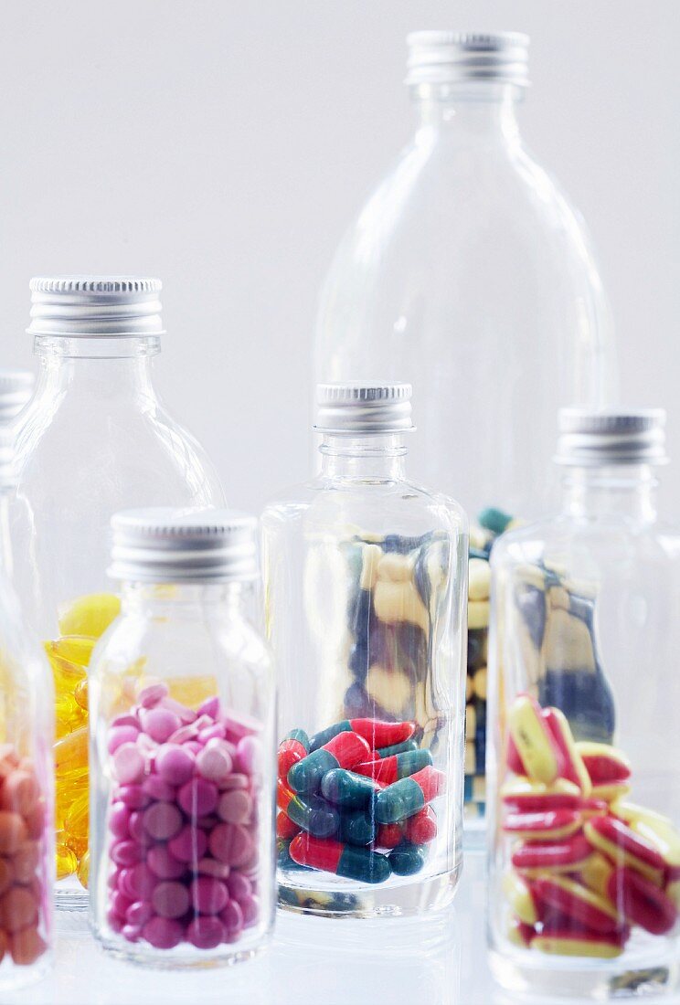 Verschiedene Kapseln und Tabletten in Flaschen
