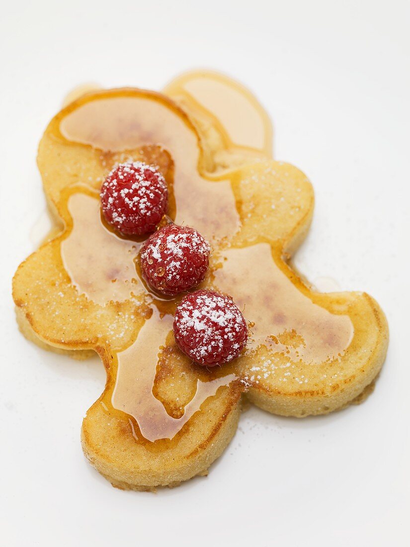 Pancake man with raspberries and maple syrup