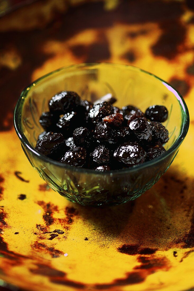 Pickled black olives in a small glass bowl