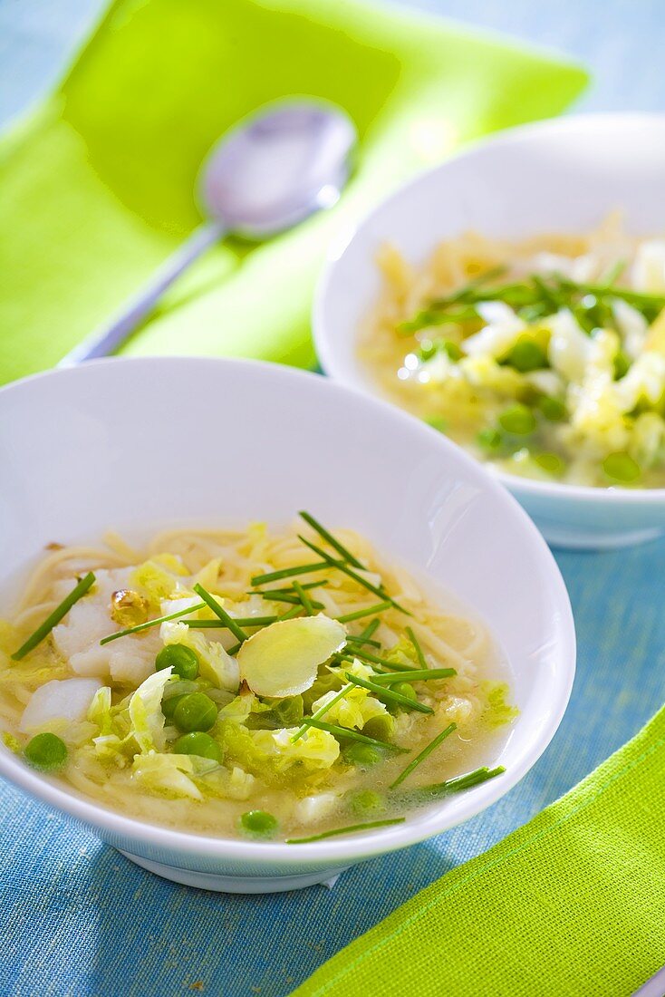Fish soup with peas, noodles, cabbage and chives