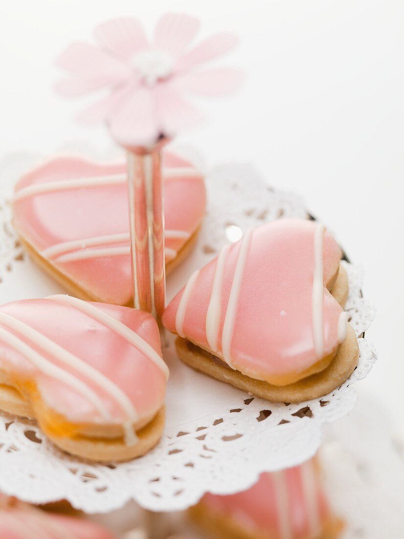Heart-shaped biscuits with pink icing on tiered stand