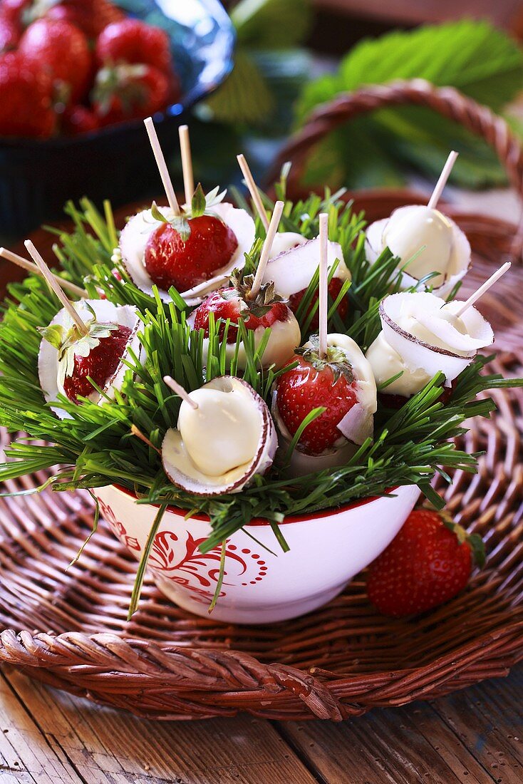 Strawberries dipped in white chocolate on cocktail sticks